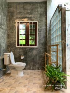 a bathroom with a toilet and a window at Aum Hum Homestay in Fang