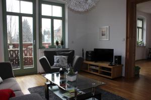 a living room with a couch and a tv at Traumhafte Etagenwohnung in Günderzeitvilla in Dresden