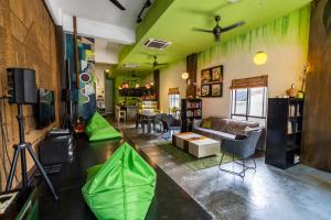 uma sala de estar com paredes verdes e um sofá em PODs The Backpackers Home & Cafe, Kuala Lumpur em Kuala Lumpur