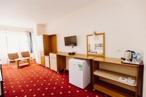 a room with a refrigerator and a desk with a mirror at Ozalp Han Hotel in Ortaca