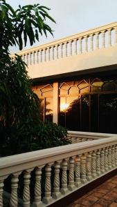 une clôture blanche devant une maison avec le coucher du soleil dans l'établissement Sagarika Beach Hotel, à Moragalla