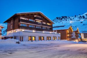 ツュルスにあるHotel Erzbergの夜雪の大きな建物