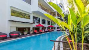 努沙杜瓦的住宿－Nunamkhalu Private Villa and Spa，酒店游泳池旁设有红色椅子