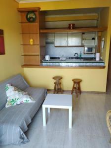 sala de estar con sofá y cocina en Primera Línea De Playa Avenida De Samil 55, en Vigo