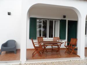 een patio met een houten tafel en stoelen bij Casa do Algarve in Alvor