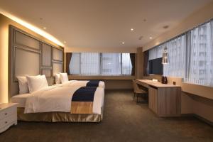 a hotel room with a large bed and a desk at Green World ZhongXiao in Taipei