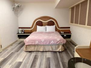 1 dormitorio con 1 cama con colcha rosa en Jia Jia Hotel, en Yonghe