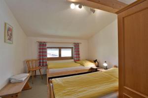 een slaapkamer met 2 bedden en een raam bij APARTMENTS Pension Foidl in Oberndorf in Tirol