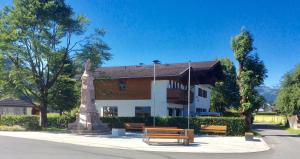 a building with two benches in front of it at APARTMENTS Pension Foidl in Oberndorf in Tirol