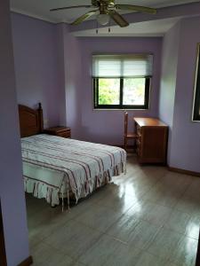 um quarto com uma cama e uma ventoinha de tecto em Piso En La Playa Samil 2 C em Vigo