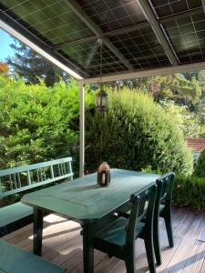 a green table on a deck with two chairs at Bed & Pool in Wiener Neustadt