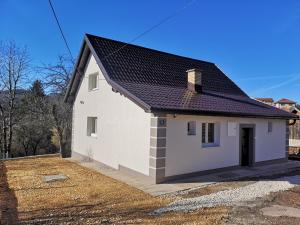 a white house with a black roof at Apartmani NiS in Pale