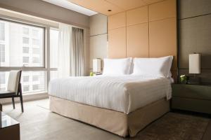 une chambre avec un grand lit et une grande fenêtre dans l'établissement Jumeirah Living Guangzhou-Complimentary Shuttle Bus to Canton Fair Complex, à Canton