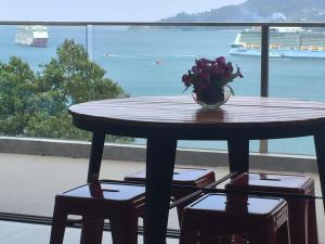 una mesa con un jarrón de flores en el balcón en 5* 3BR SUITE in Amari Phuket - Patong Beach en Patong Beach