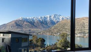 a view of a lake and mountains from a window at GoldRush Haven in Queenstown