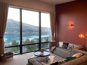 a living room with a couch and a large window at GoldRush Haven in Queenstown
