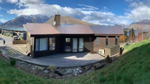 a small house with a deck on a hill at GoldRush Haven in Queenstown +8 photos