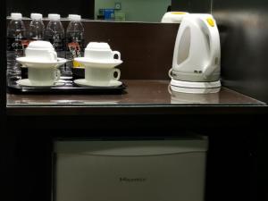 a kitchen counter with two cups and a coffee maker at Kimberley Hotel Georgetown in George Town