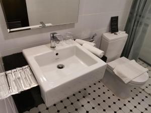 a white bathroom with a sink and a toilet at Kimberley Hotel Georgetown in George Town