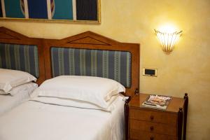 um quarto com uma cama e uma mesa de cabeceira com uma cama sidx sidx em Best Western Hotel Artdeco em Roma