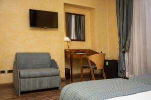 una camera d'albergo con letto, sedia e scrivania di Best Western Hotel Artdeco a Roma