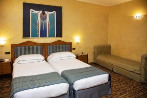 una camera d'albergo con due letti e un dipinto sul muro di Best Western Hotel Artdeco a Roma