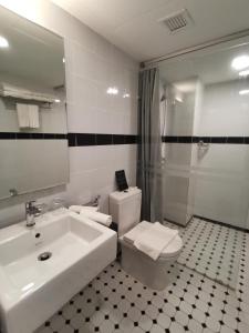 a bathroom with a sink and a toilet and a shower at Kimberley Hotel Georgetown in George Town