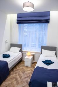 two beds in a room with a window at Hot Spot Vilnius Apartments in Vilnius