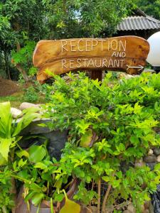 un letrero para la recepción y el restaurante en un jardín en Mai Chau Xanh Bungalow en Mai Chau