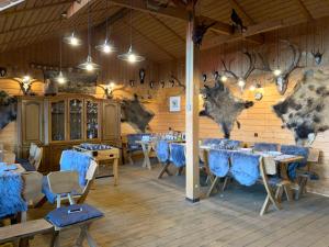 a dining room with tables and blue chairs and lights at Willa Karkonoska - klimatyczne pokoje i studia z ANEKSAMI KUCHENNYMI - Śniadania Sauna Grota Solna Siłownia Parking WI-FI W CENIE in Karpacz
