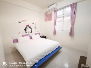 1 dormitorio con cama blanca y ventana en 玖號民宿, en Jincheng