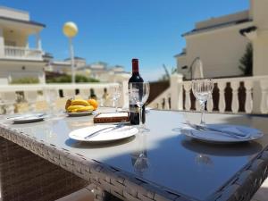 una mesa con una botella de vino y copas en Villa Paradise Campello, en El Campello