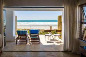a room with two chairs and a view of the beach at Deja-Vu in Paternoster