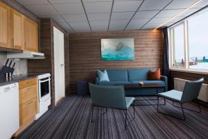 a living room filled with furniture and a kitchen at Svalbard Hotell | Lodge in Longyearbyen