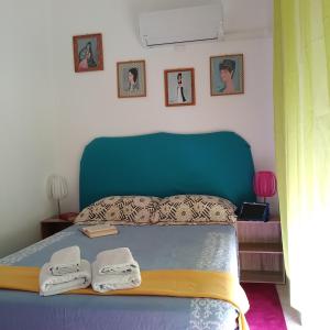 a bedroom with a blue bed with towels on it at Stella di mare in Cagliari