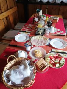 una mesa con platos de comida en un mantel rojo en Grill Garten Vendégház, en Keszthely