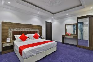 a bedroom with a large bed and a mirror at Qasr Al Hamra ApartHotel Al Hamra Branch in Jeddah