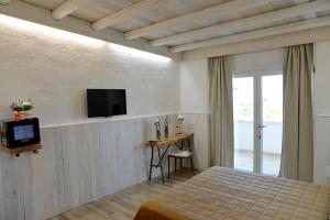 a bedroom with a bed and a tv on a wall at Masseria Santa Teresa in Monopoli
