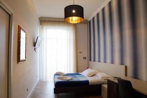 ein Schlafzimmer mit einem Bett und einem großen Fenster in der Unterkunft Garibaldi Rooms in Neapel