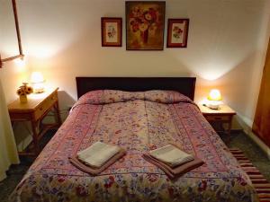a bedroom with a bed with two tables and two lamps at Casa Esperanza in Málaga