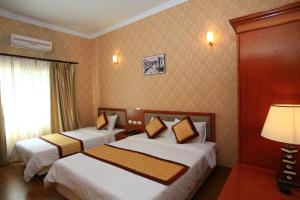 una camera d'albergo con due letti e una lampada di ATS Hotel a Hanoi