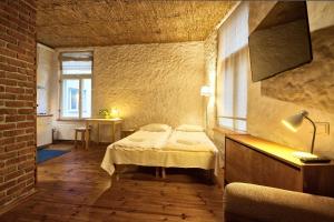 una camera con un letto in una stanza con un muro di mattoni di Flatmanagement Kaupmehe Apartments a Tallinn