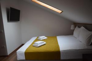 1 dormitorio con 1 cama con 2 toallas en Crema Residence en Alba Iulia