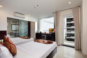
a bedroom with a large bed and a large window at Azura Hotel in Nha Trang
