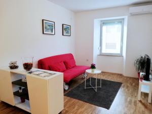 a living room with a red chair and a table at City center apartment in Umag