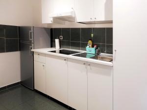 a white kitchen with a sink and a refrigerator at City center apartment in Umag