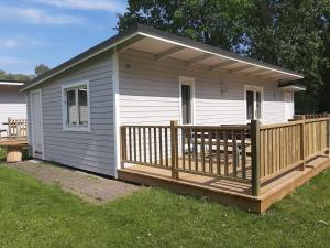 Casa blanca pequeña con terraza de madera en Trelleborg Strand, en Trelleborg