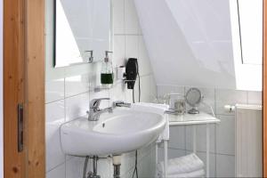 bagno bianco con lavandino e specchio di Landhaus Schmitt a Sommerach