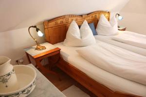 una camera d'albergo con letto e cuscini bianchi di Landhaus Schmitt a Sommerach