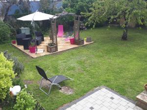 a garden with chairs and an umbrella in the grass at Carpe Diem Bed & Breakfast in Sélestat